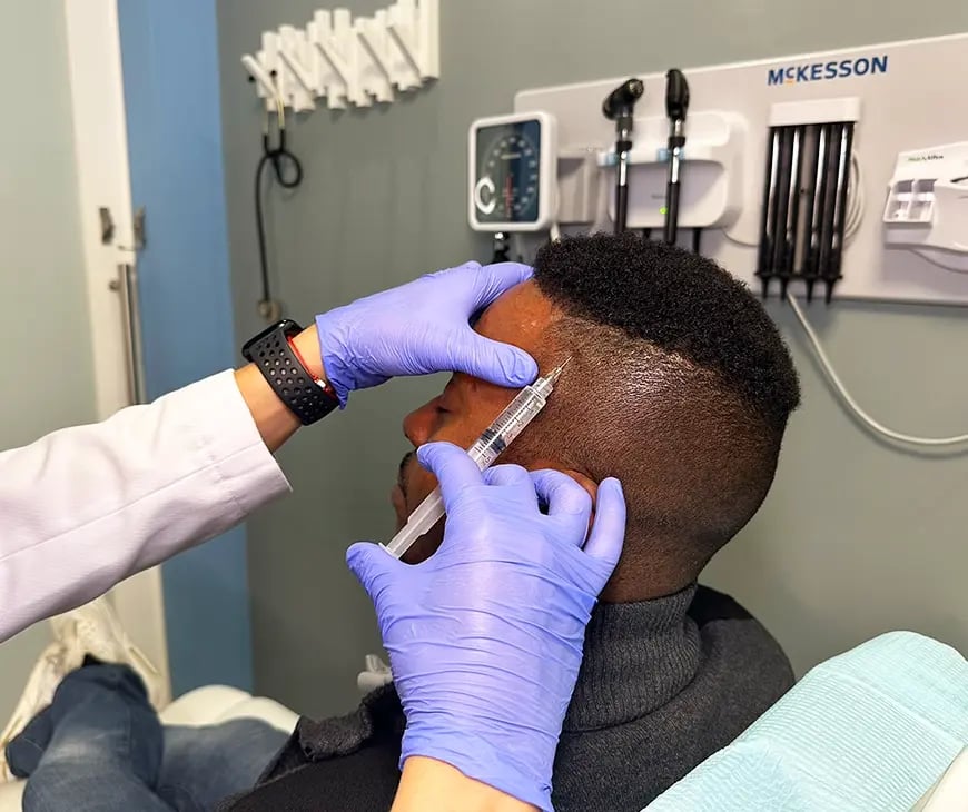 Black man being injected with PRP on his scalp at Liquivida Wellness Center