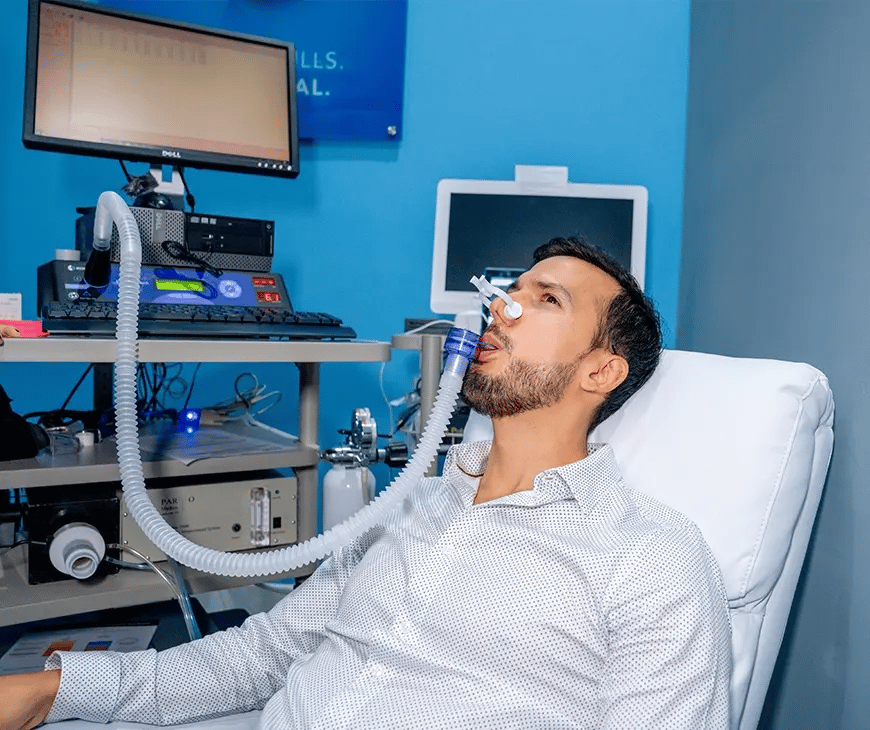 Male with a tube connected to his mouth as he waits results of the RMR analysis in his Enlightened Living Program at Liquivida Wellness Center