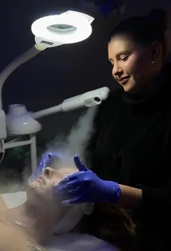 Practitioner preparing a patient's face for a facial treatment at Liquivida Middletown