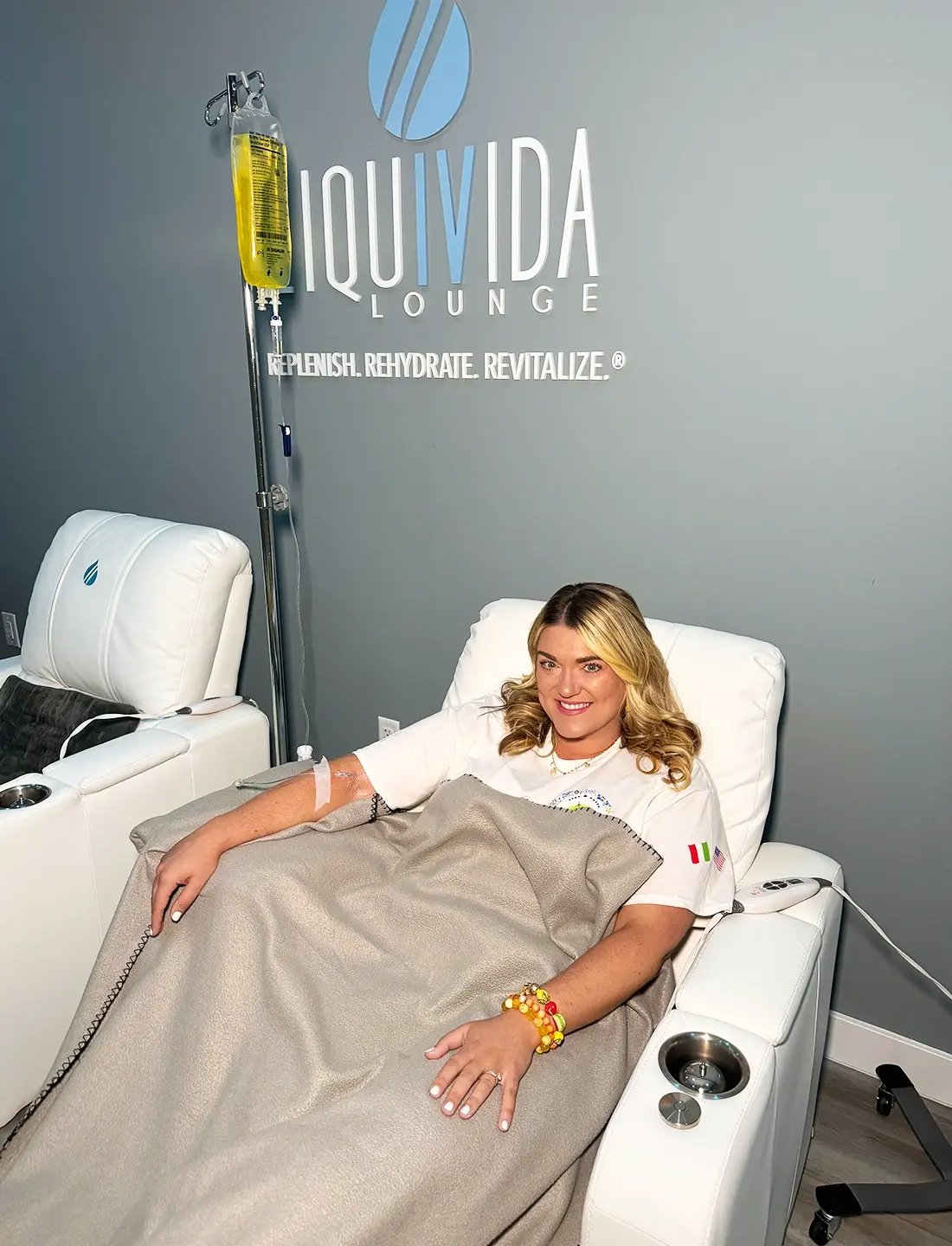 Blond woman relaxed in a lounge getting an IV drip at Liquivida Wellness Center Middletown