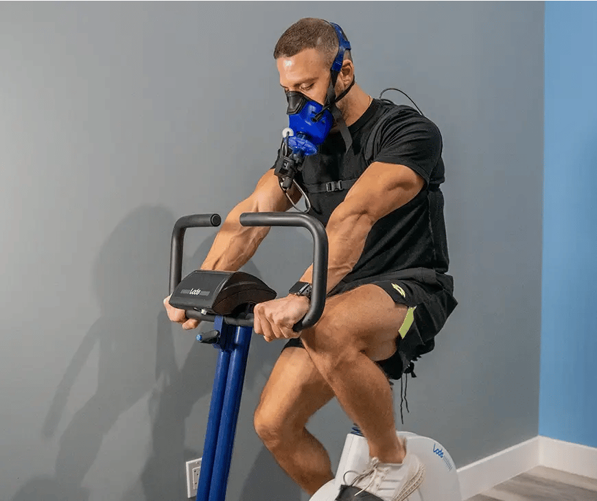 Fit man riding a static bike while he completes a VO2 Max test at Liquivida Wellness Center