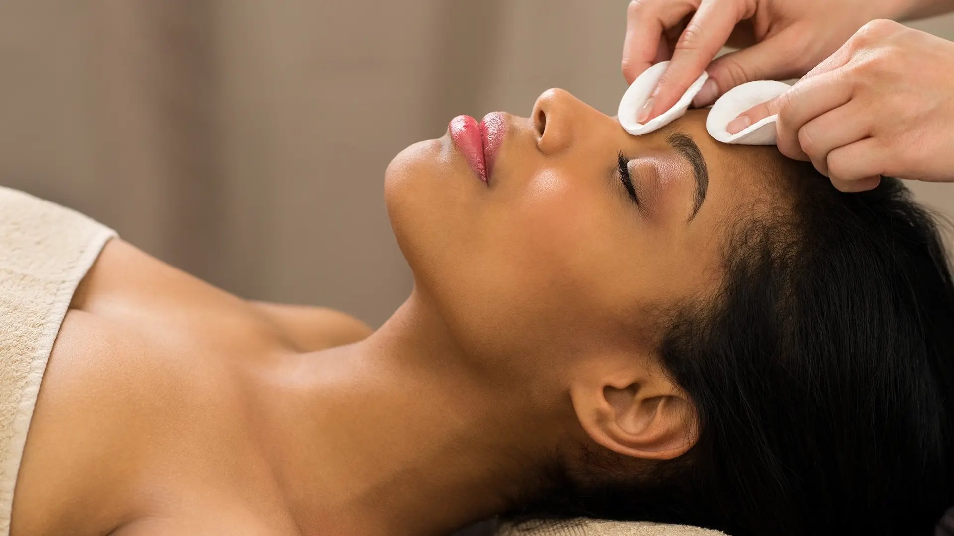 A beautiful black woman's face is being cleaned for a Chemical Peel at Liquivida Wellness Center