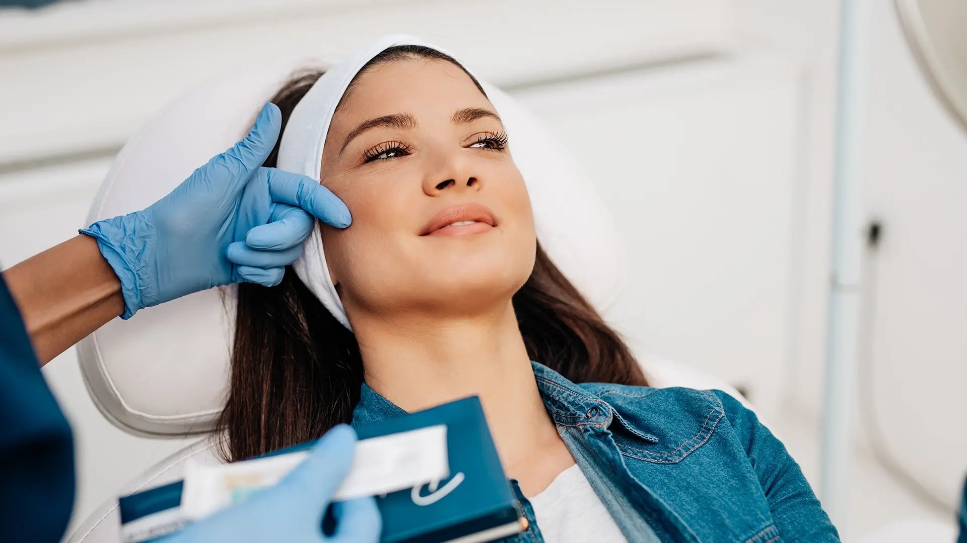 Practitioner evaluates the face of a woman before applying Restylane at Liquivida Wellness Center
