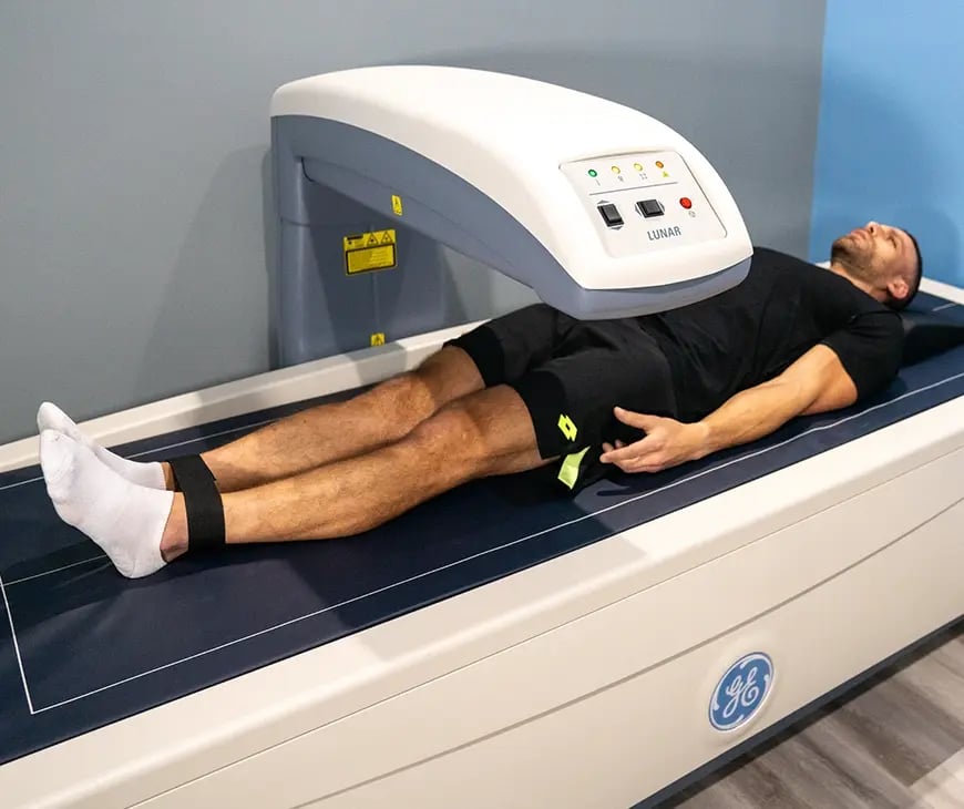 Male laying down under a DEXA scan included in the Enlightened Living Program at Liquivida Wellness Center
