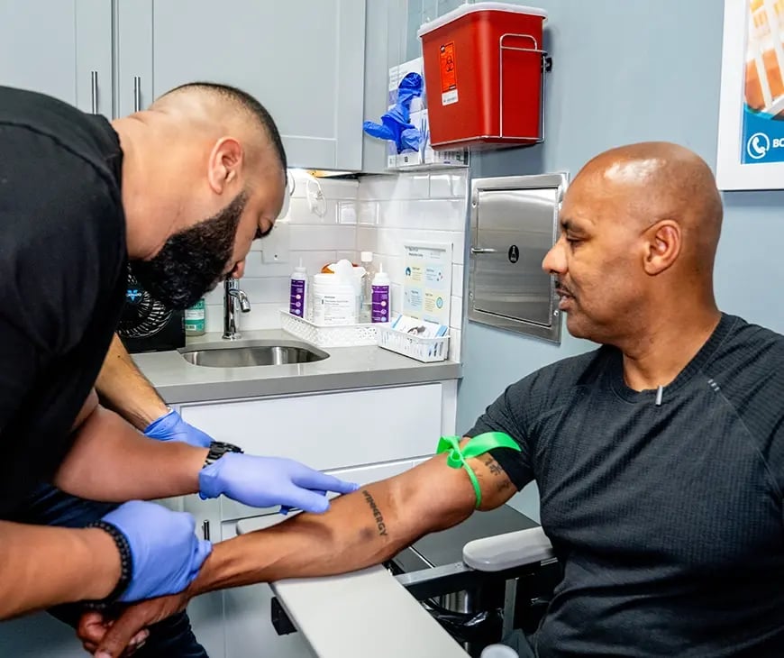 Male checking a patient's arm to recommend supplements included in the Enlightened Living Program at Liquivida Wellness Center
