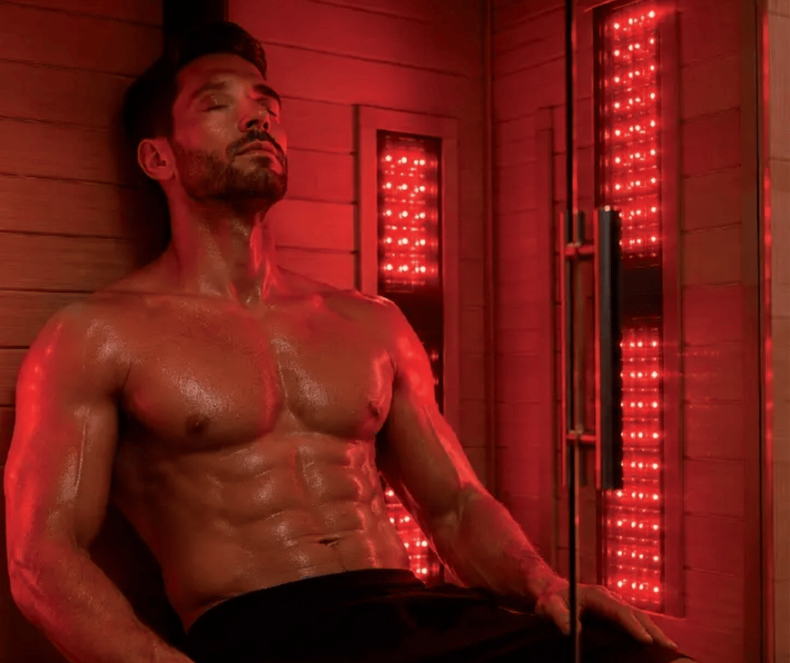 A man sitting inside a sauna while getting infrared light therapy at Liquivida