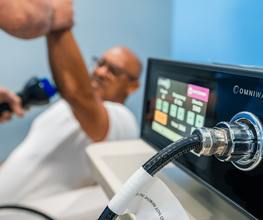 An OMNIWave machine is being used on Cory Jacobs' arm at Liquivida