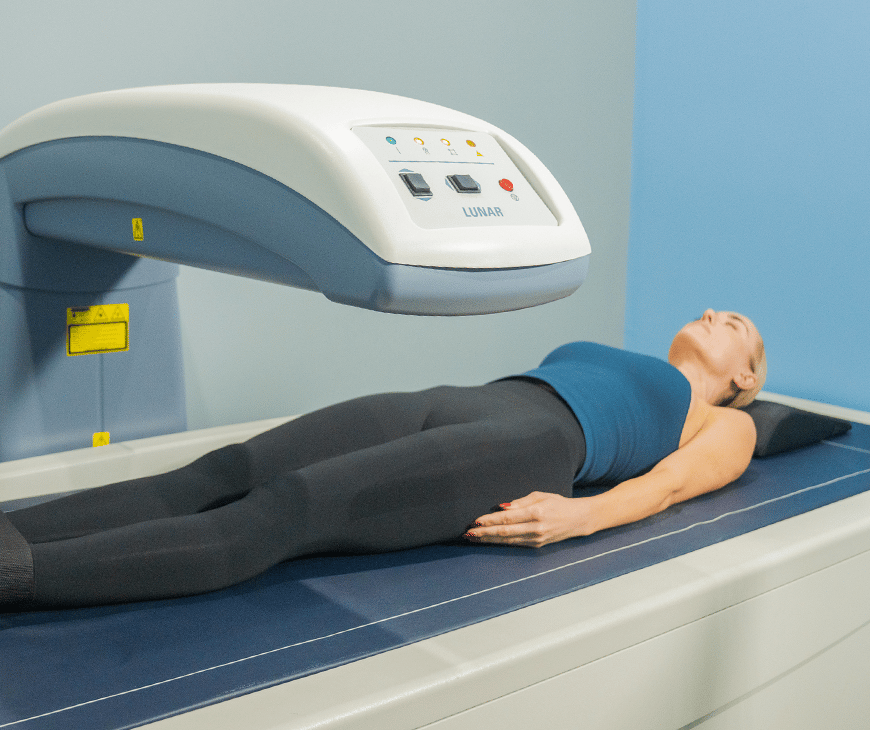 Woman laying down while a DEXA machine scans her body at Liquivida