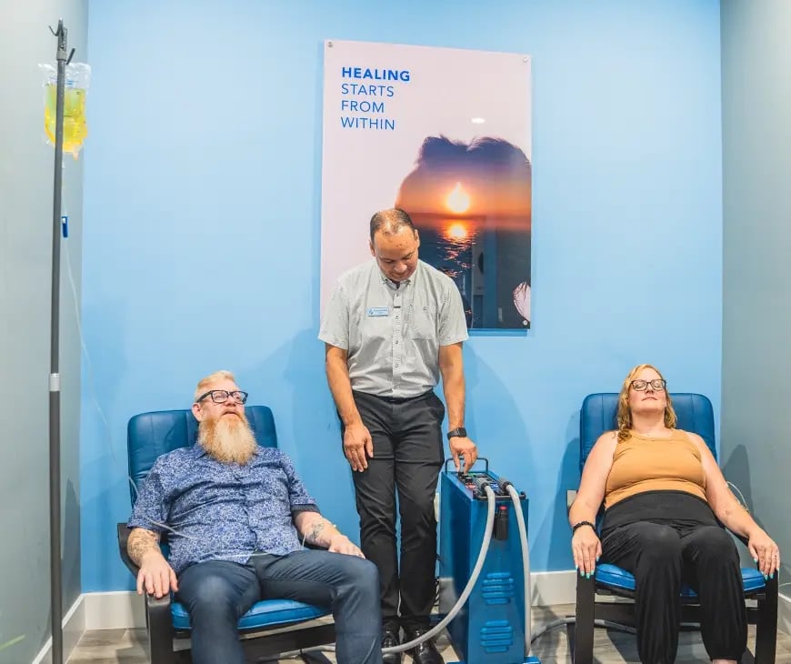 A couple sitting on a PEMF chair at Liquivida Wellness Center