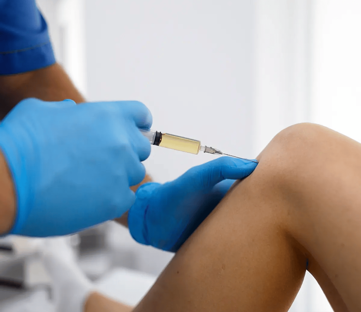 Practitioner applying a regenerative joint injection in the leg of a patient at Liquivida