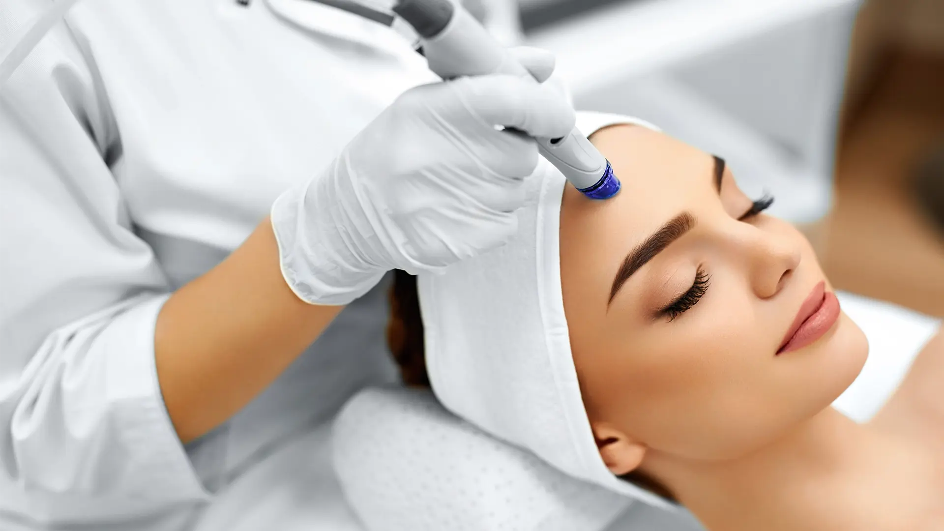 Practitioner performing Microdermabrasion on a woman´s forehead at Liquivida Wellness Center